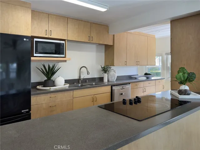 a kitchen with stainless steel appliances a sink a stove a microwave a sink and cabinets