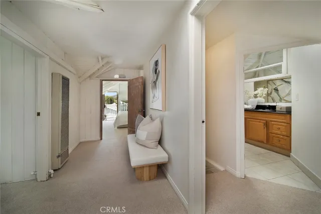 a hallway with white cabinets and wooden floor