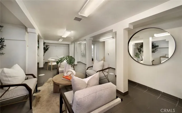 a living room with furniture a mirror and a painting on the wall