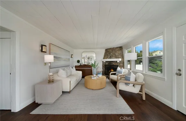 a living room with furniture a fireplace and large windows