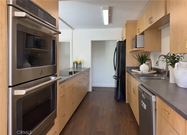 a kitchen with stainless steel appliances a sink stove and refrigerator