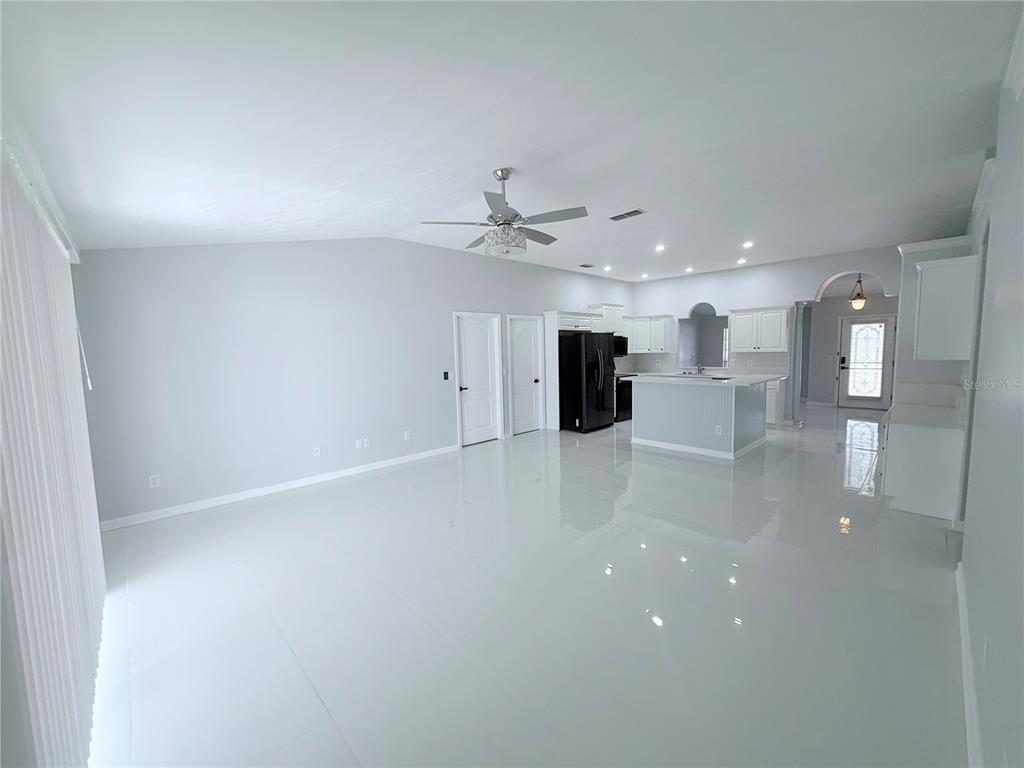 465 Haversham Road Deltona, FL 32725 - Photo 2 of 20 an empty room with wooden floor and a ceiling fan