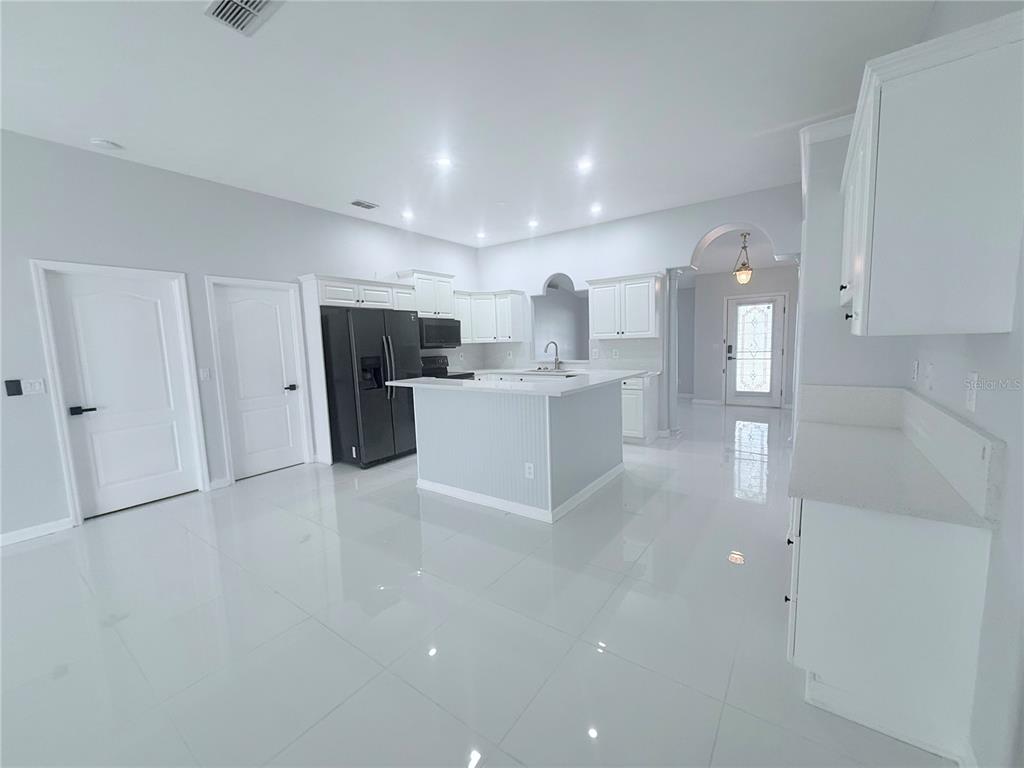 465 Haversham Road Deltona, FL 32725 - Photo 3 of 20 a view of a kitchen with refrigerator and white cabinets