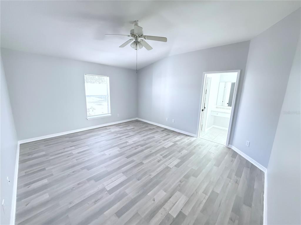 465 Haversham Road Deltona, FL 32725 - Photo 9 of 20 an empty room with wooden floor chandelier and windows