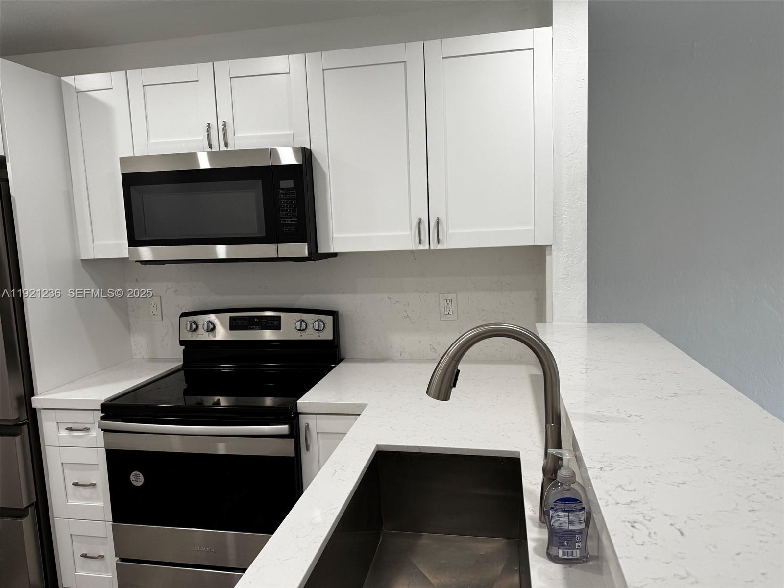 2034 Taylor Street Hollywood, FL 33020 - Photo 16 of 35 a kitchen with a stove and a microwave