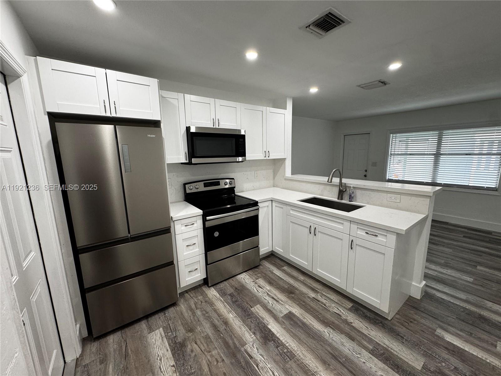 2034 Taylor Street Hollywood, FL 33020 - Photo 27 of 35 a kitchen with stainless steel appliances a refrigerator sink and microwave