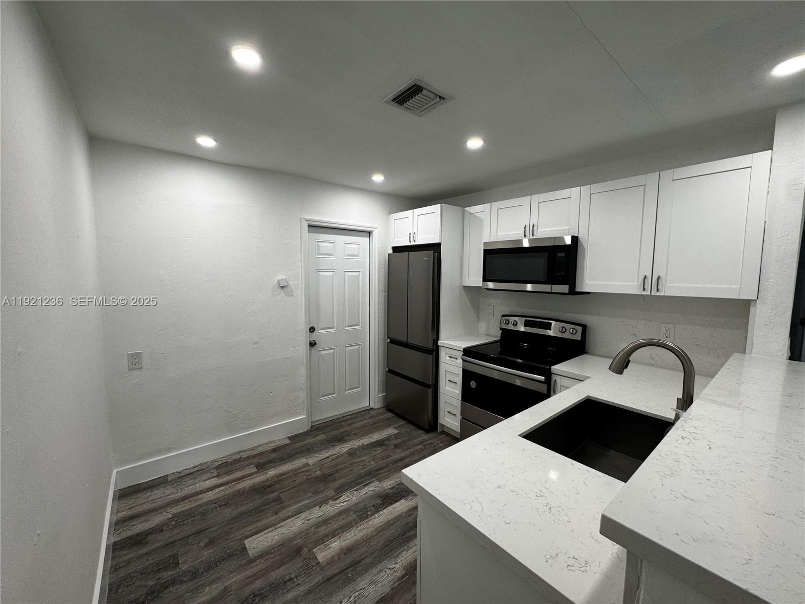 2034 Taylor Street Hollywood, FL 33020 - Photo 33 of 35 a kitchen with a refrigerator a microwave a stove and cabinets