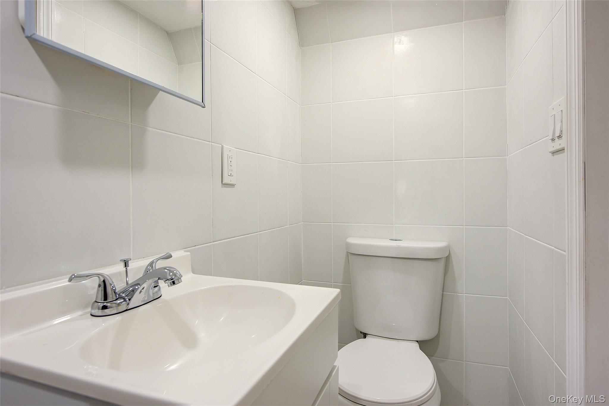 164-38 76th Road Queens, NY 11366 - Photo 33 of 44 a bathroom with a sink a toilet and mirror