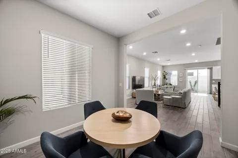 a living room with furniture a wooden floor and a kitchen view