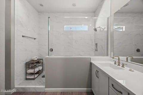 a bathroom with a double vanity sink a toilet and shower