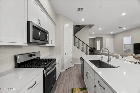 a kitchen with stainless steel appliances granite countertop a sink a stove microwave and refrigerator