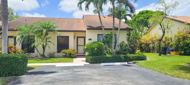 a view of a house with a yard and potted plants
