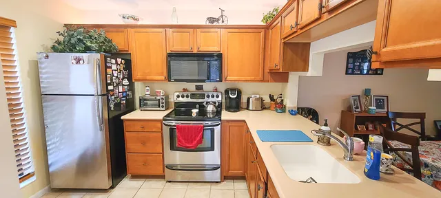 a view of a kitchen with furniture and a refrigerator