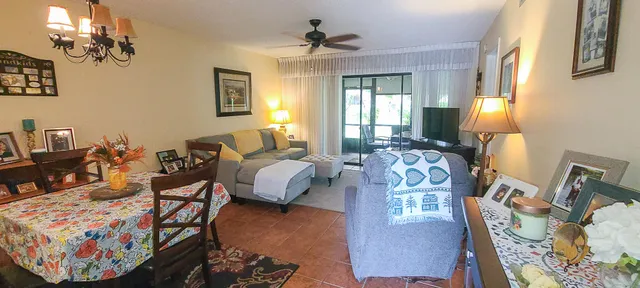 a spacious bedroom with bed a couch and a chandelier