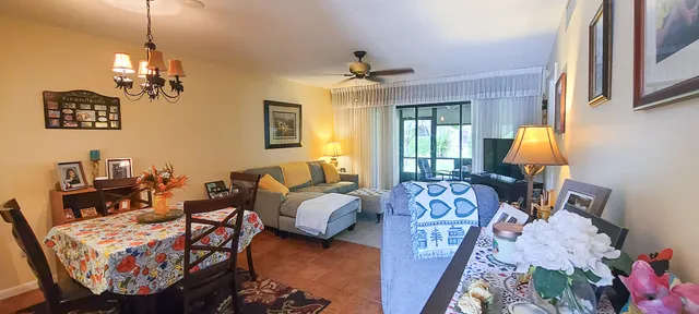 a living room with furniture a chandelier and a dining table
