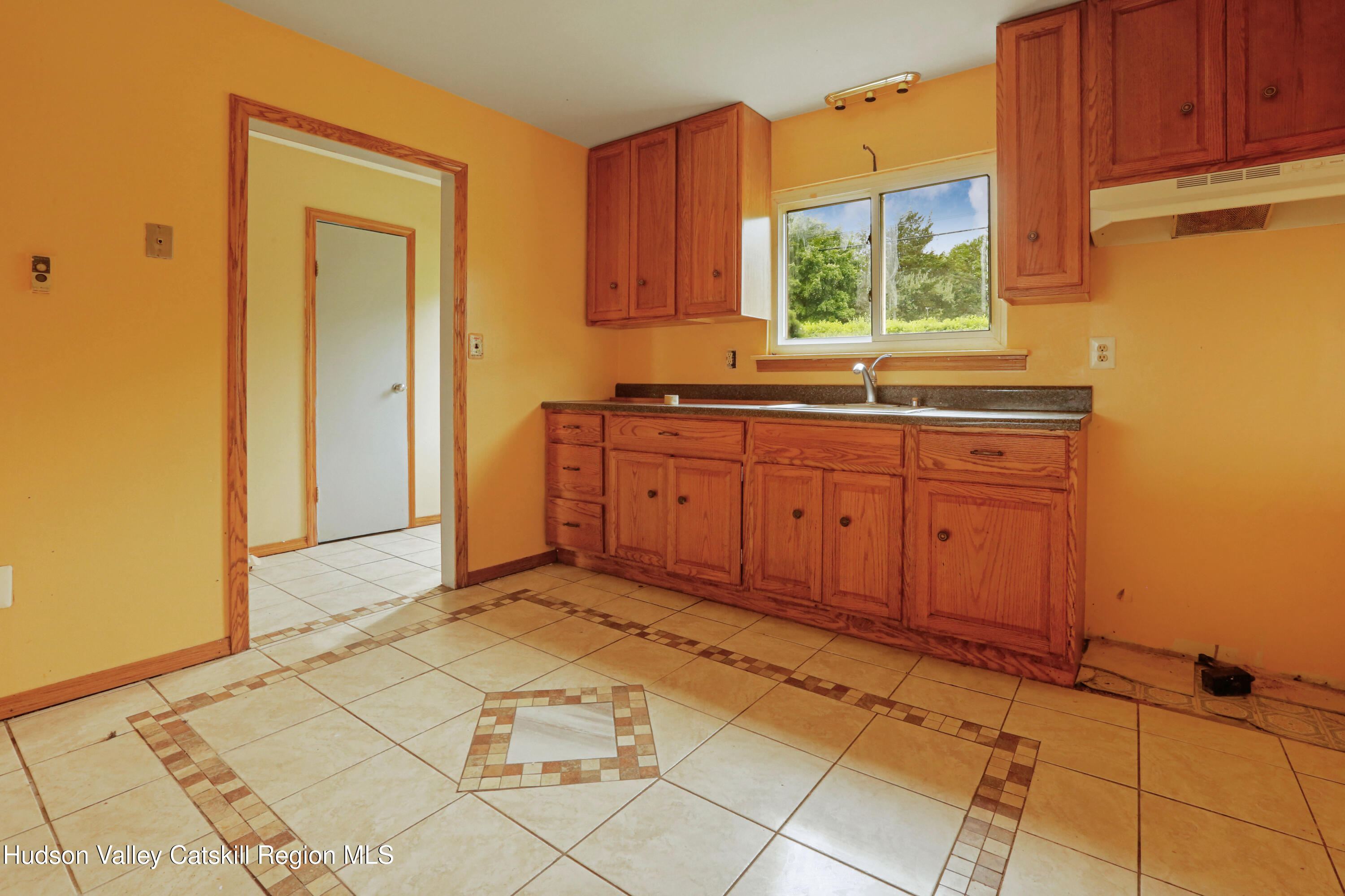 881 Albany Post Road, Unit 5 New Paltz, NY 12561 - Photo 7 of 16 a view of a kitchen with a sink window and cabinets