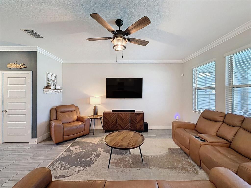 8124 Olympic Stone Circle Trinity, FL 34655 - Photo 11 of 75 a living room with furniture a ceiling fan and a window
