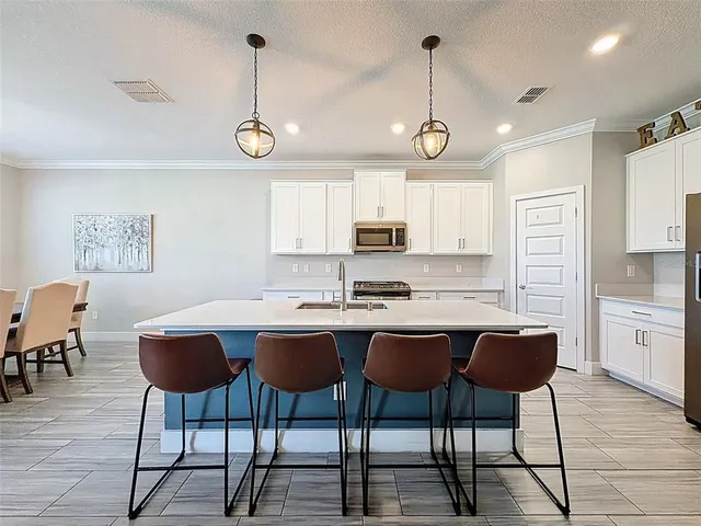 a kitchen with stainless steel appliances granite countertop a sink a stove and a wooden floors