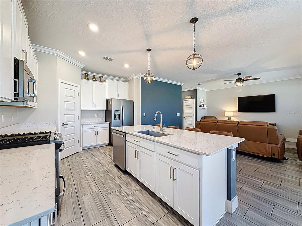 8124 Olympic Stone Circle Trinity, FL 34655 - Photo 18 of 75 a kitchen that has a lot of cabinets in it and wooden floors