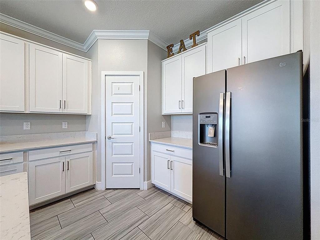 8124 Olympic Stone Circle Trinity, FL 34655 - Photo 22 of 75 a kitchen with stainless steel appliances a refrigerator sink and cabinets