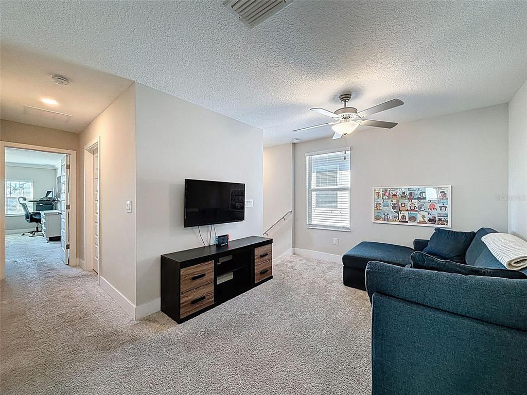 8124 Olympic Stone Circle Trinity, FL 34655 - Photo 34 of 75 a living room with furniture and a flat screen tv