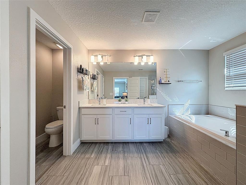 8124 Olympic Stone Circle Trinity, FL 34655 - Photo 38 of 75 a bathroom with a bathtub shower sink mirror and toilet