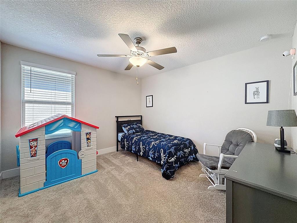 8124 Olympic Stone Circle Trinity, FL 34655 - Photo 45 of 75 a bedroom with a bed and a chandelier