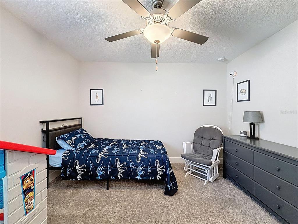 8124 Olympic Stone Circle Trinity, FL 34655 - Photo 46 of 75 a bedroom with bed and a chandelier