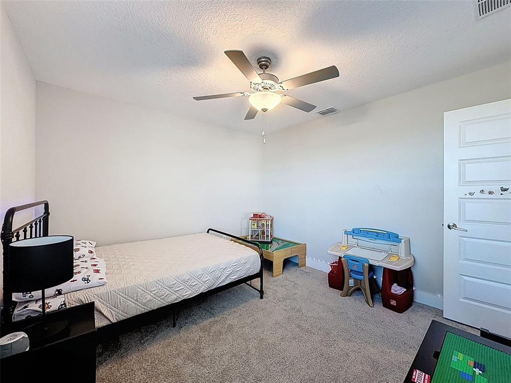 8124 Olympic Stone Circle Trinity, FL 34655 - Photo 51 of 75 a bedroom with a bed and a chandelier