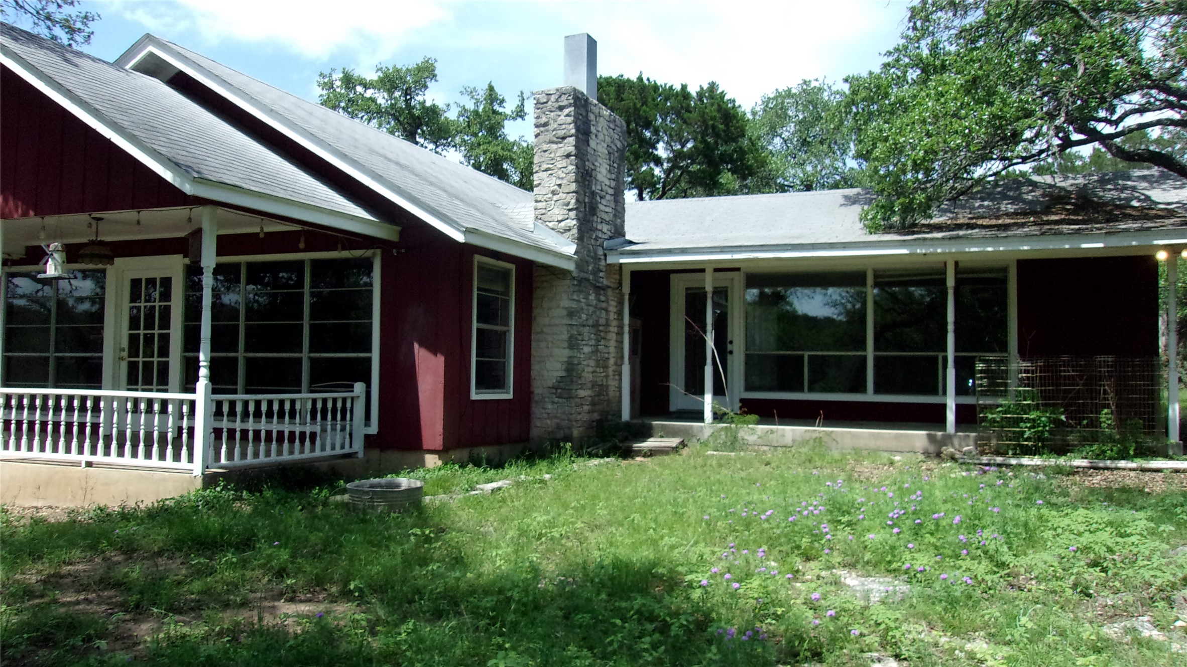 702 Cottonwood Creek Road Dripping Springs, TX 78620 - Photo 1 of 31 Red exterior siding with a stone chimney feature