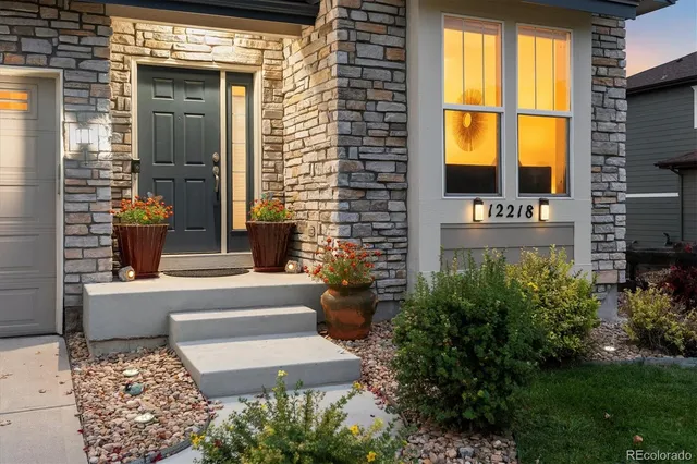 a front view of a house with a garden and trees