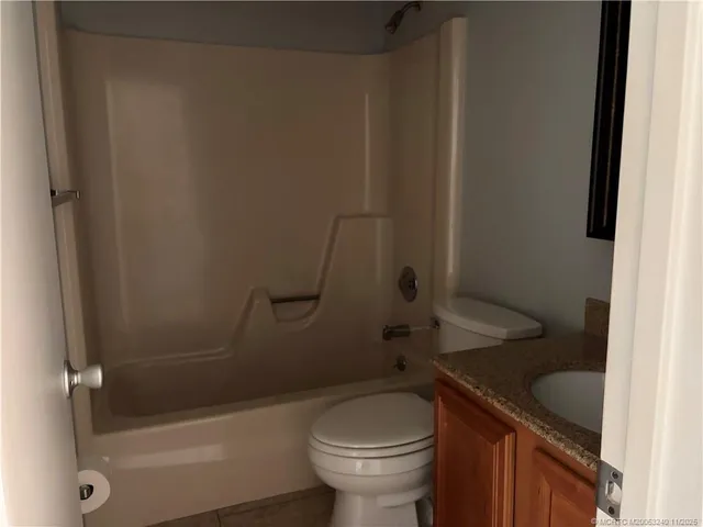a bathroom with a granite countertop toilet a sink and bathtub
