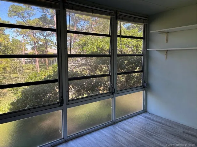 a view of a room with wooden floor and windows