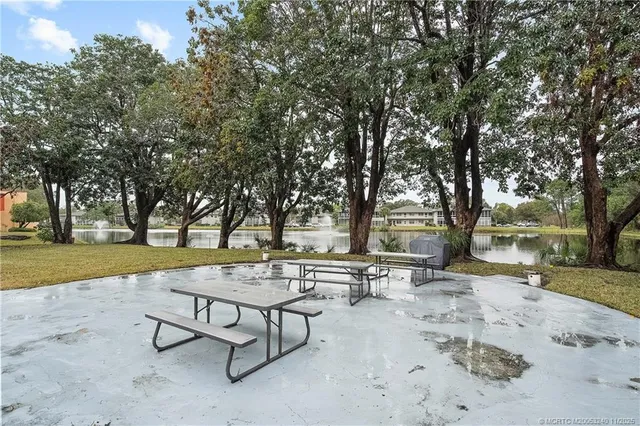 a view of swimming pool with chairs and trees