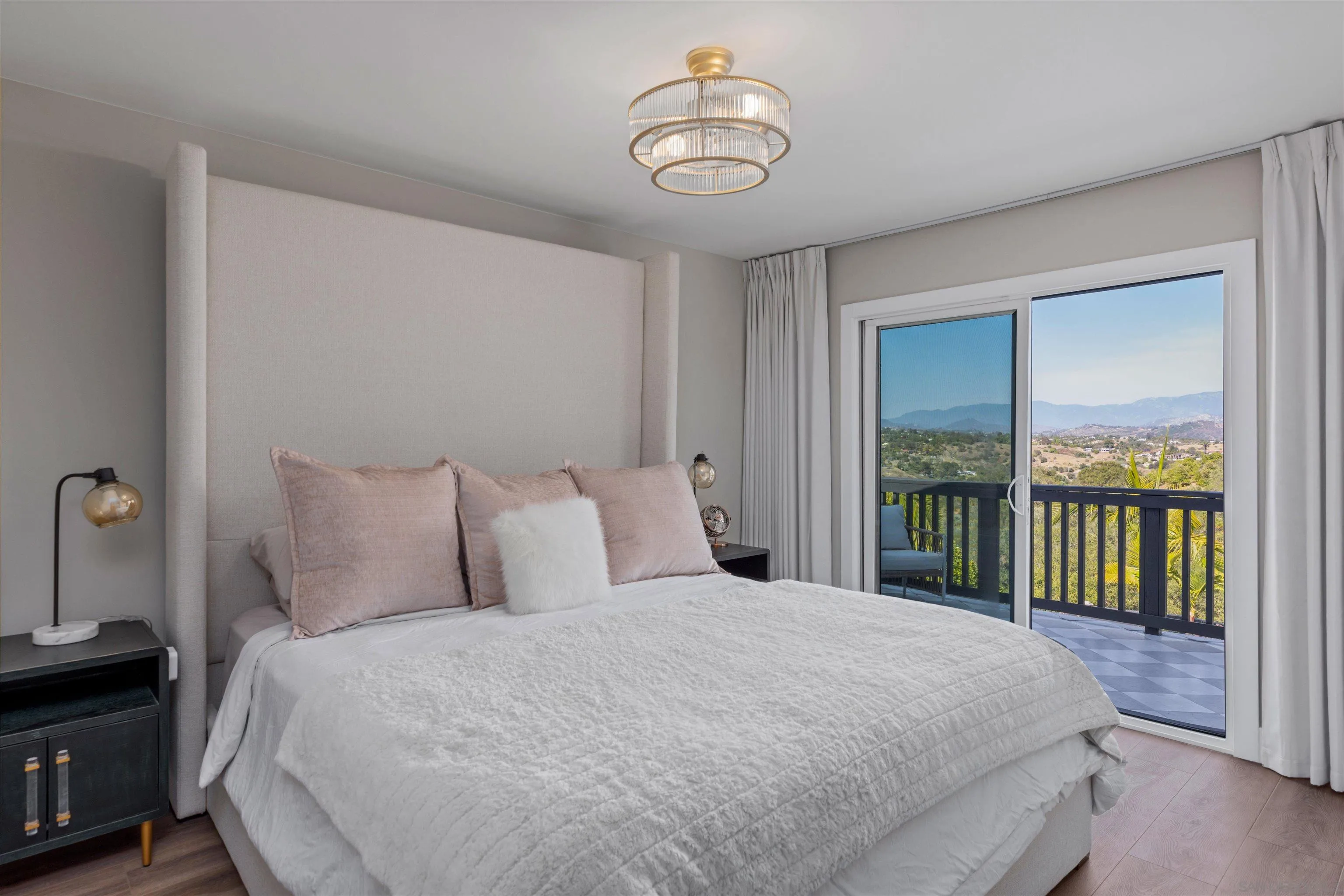 521 Rancho Camino Fallbrook, CA 92028 - Photo 35 of 72 a bedroom with a large bed and a chandelier