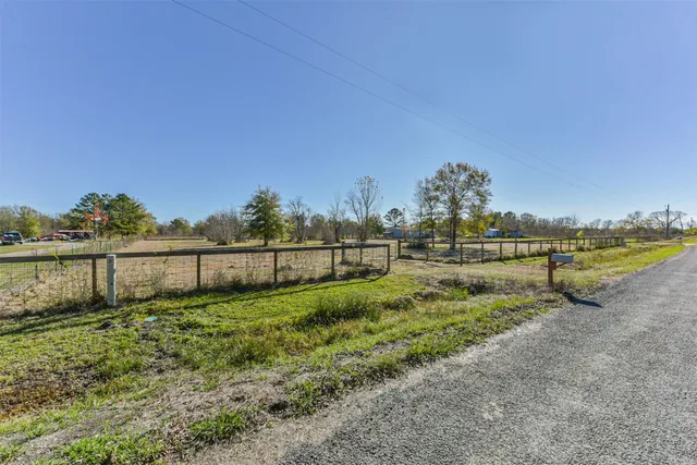 a view of a yard with wooden fence