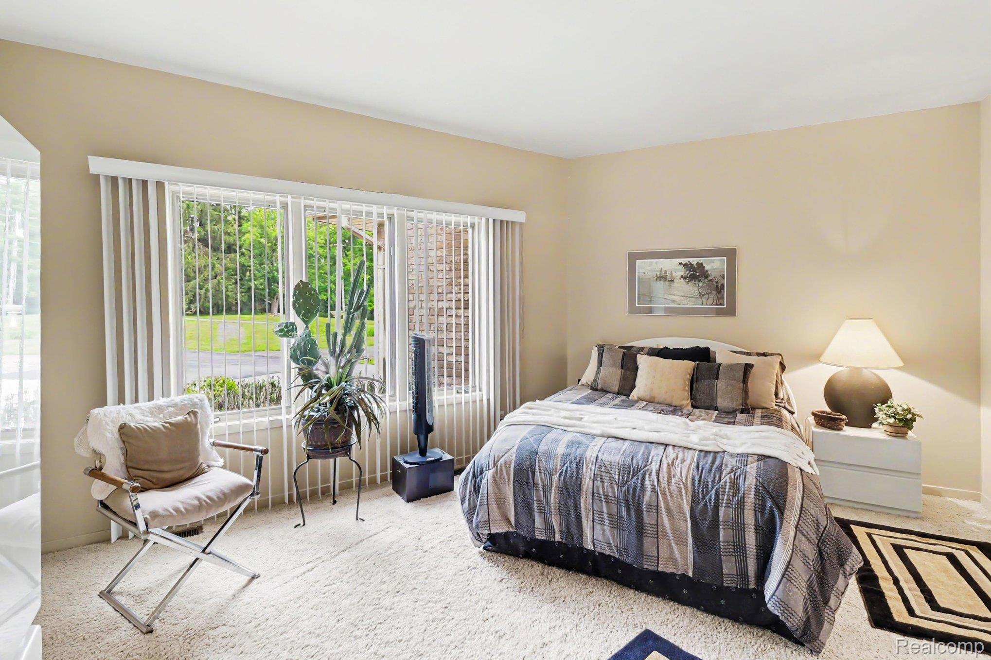 18501 Taylor Lake Road Holly, MI 48442 - Photo 20 of 35 Carpeted room featuring a multi-pane window with vertical blinds, providing abundant natural light