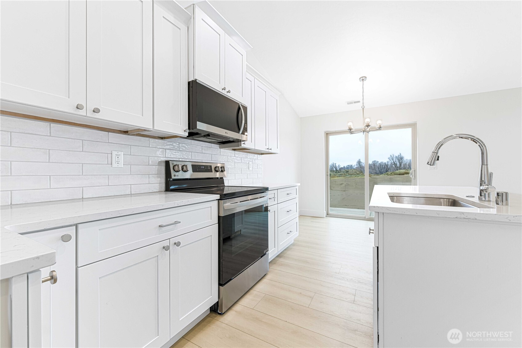 4259 Sandy Street Moses Lake, WA 98837 - Photo 6 of 21 a kitchen with stainless steel appliances granite countertop a sink a stove a microwave and wooden cabinets