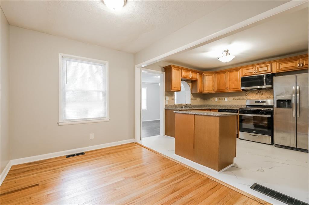 2965 Judylyn Drive Decatur, GA 30033 - Photo 6 of 26 a kitchen with stainless steel appliances granite countertop a refrigerator a sink dishwasher a stove with wooden cabinets and floor