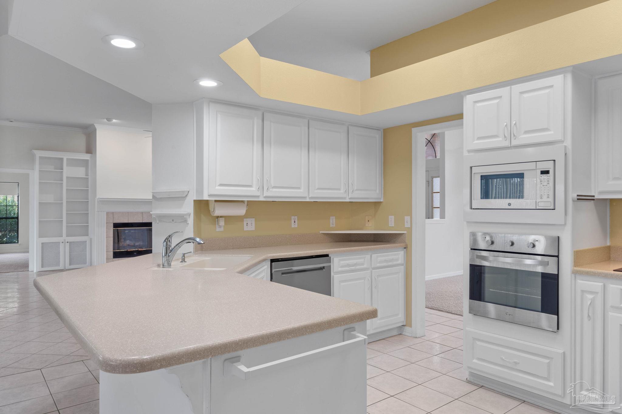 2640 Masters Boulevard Navarre, FL 32566 - Photo 13 of 40 a kitchen with granite countertop white cabinets and stainless steel appliances