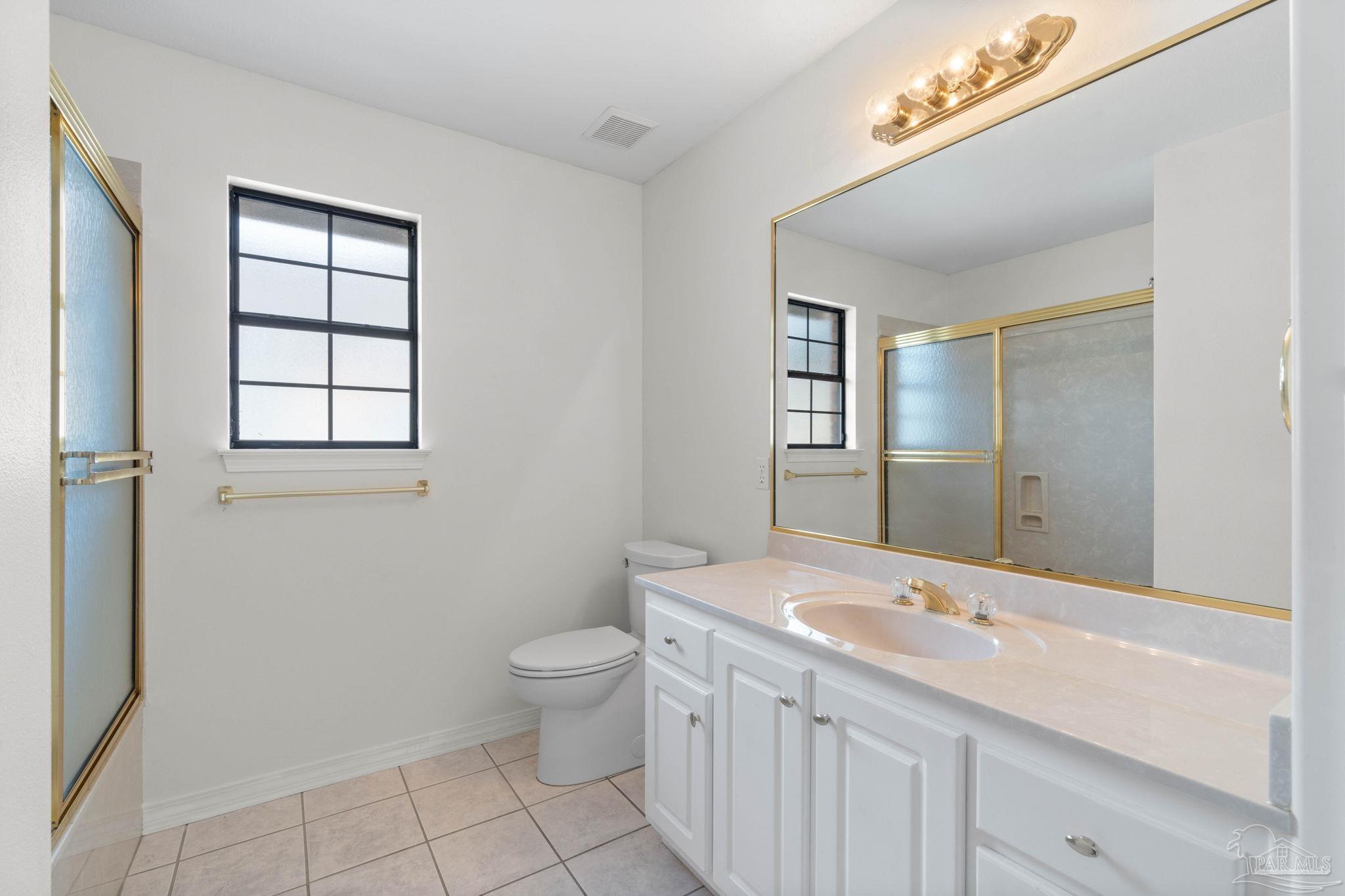 2640 Masters Boulevard Navarre, FL 32566 - Photo 17 of 40 a bathroom with a sink a toilet and mirror