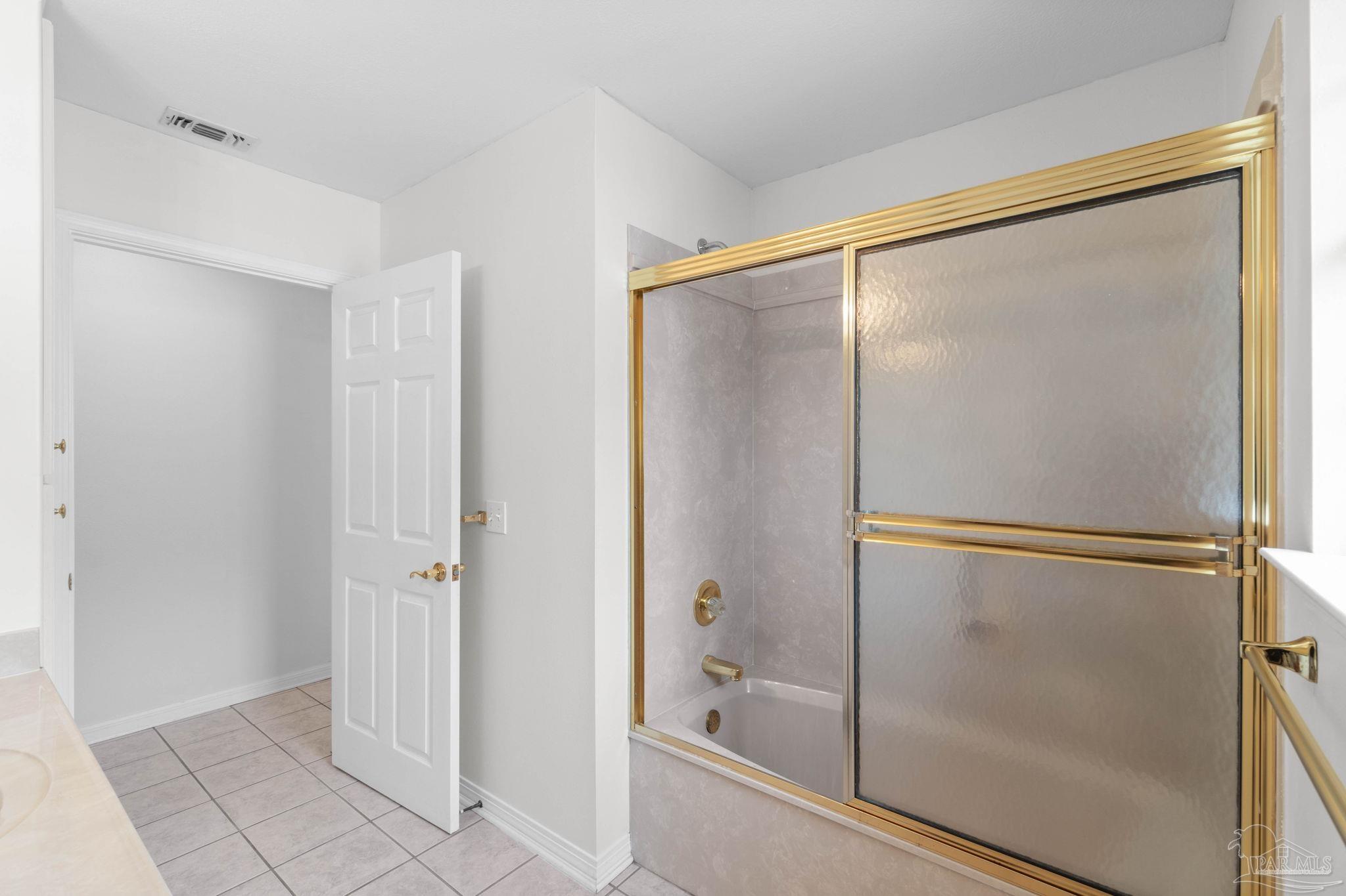 2640 Masters Boulevard Navarre, FL 32566 - Photo 18 of 40 a bathroom with a glass shower door