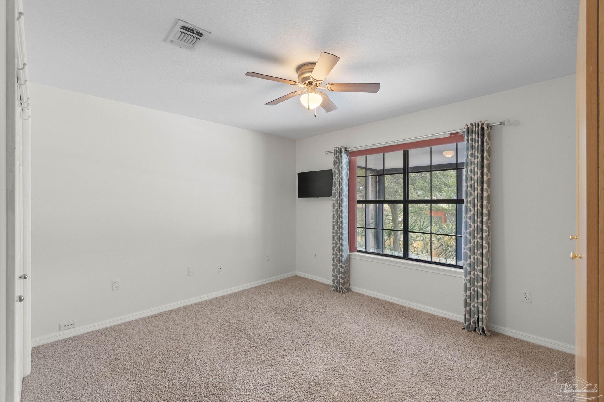 2640 Masters Boulevard Navarre, FL 32566 - Photo 19 of 40 an empty room with windows and fan