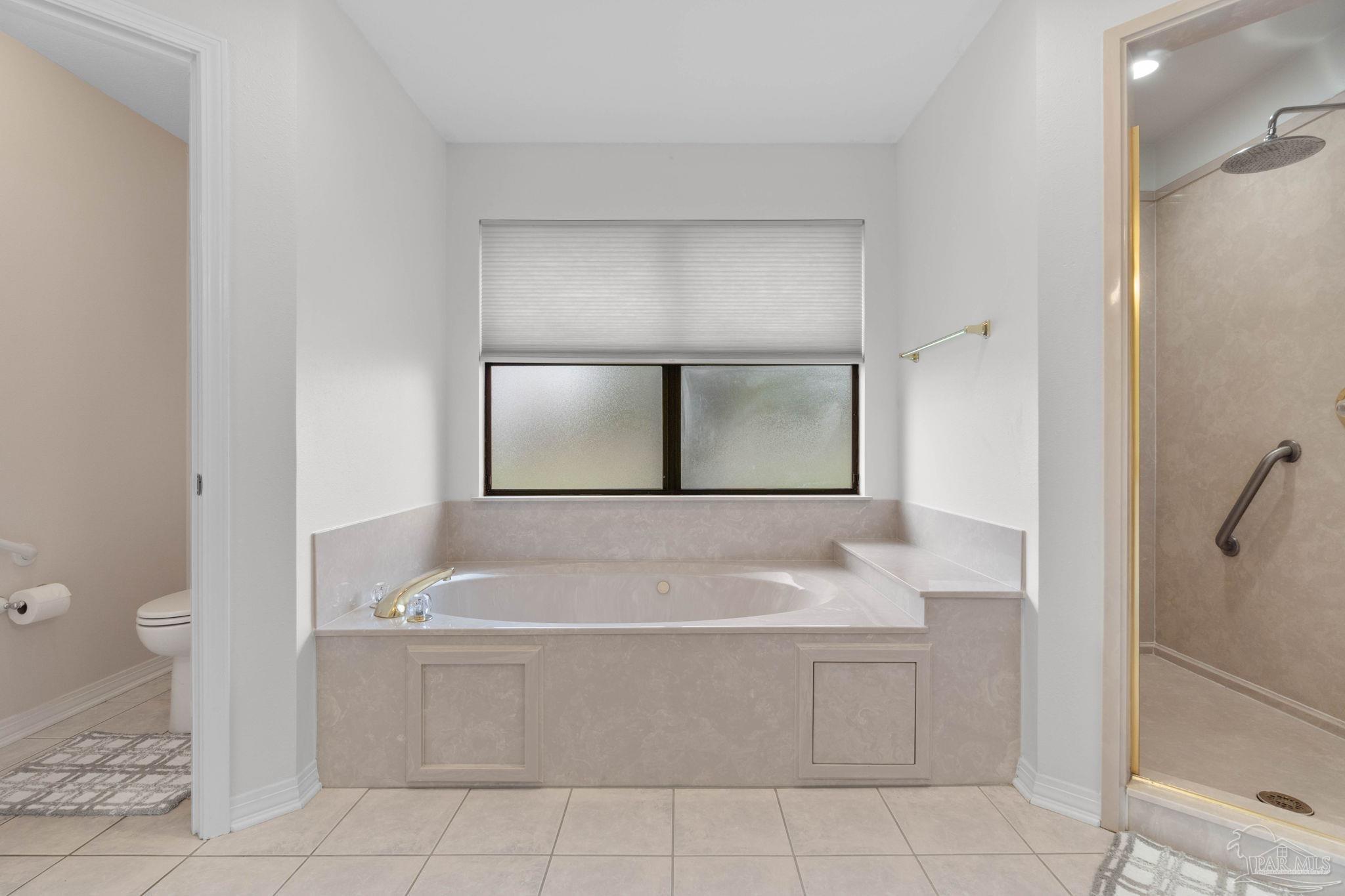 2640 Masters Boulevard Navarre, FL 32566 - Photo 22 of 40 a bathroom with a bathtub and mirror