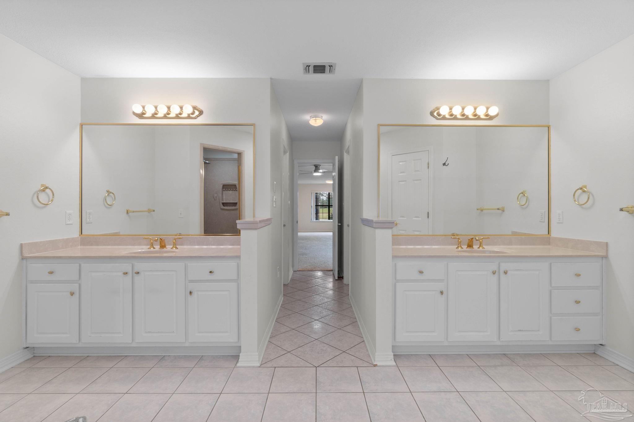 2640 Masters Boulevard Navarre, FL 32566 - Photo 23 of 40 a spacious bathroom with a granite countertop sink a mirror a shower and a bathtub