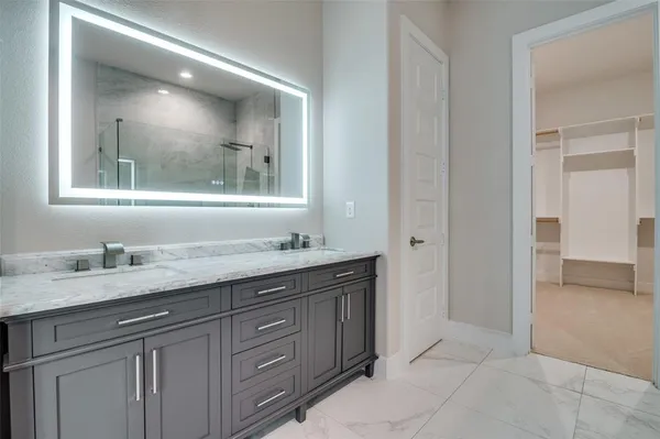 a bathroom with a granite countertop sink mirror and cabinets