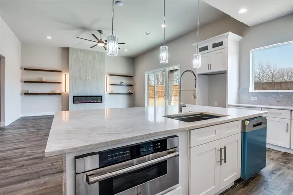 a kitchen with stainless steel appliances granite countertop a stove and a wooden floors