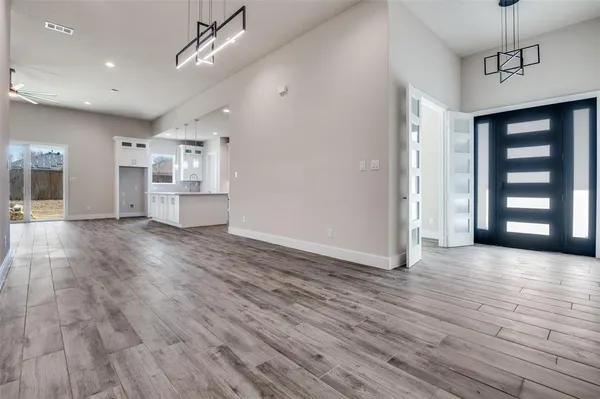 a view of a big room with wooden floor and windows