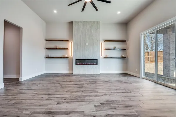 a view of empty room with wooden floor and window
