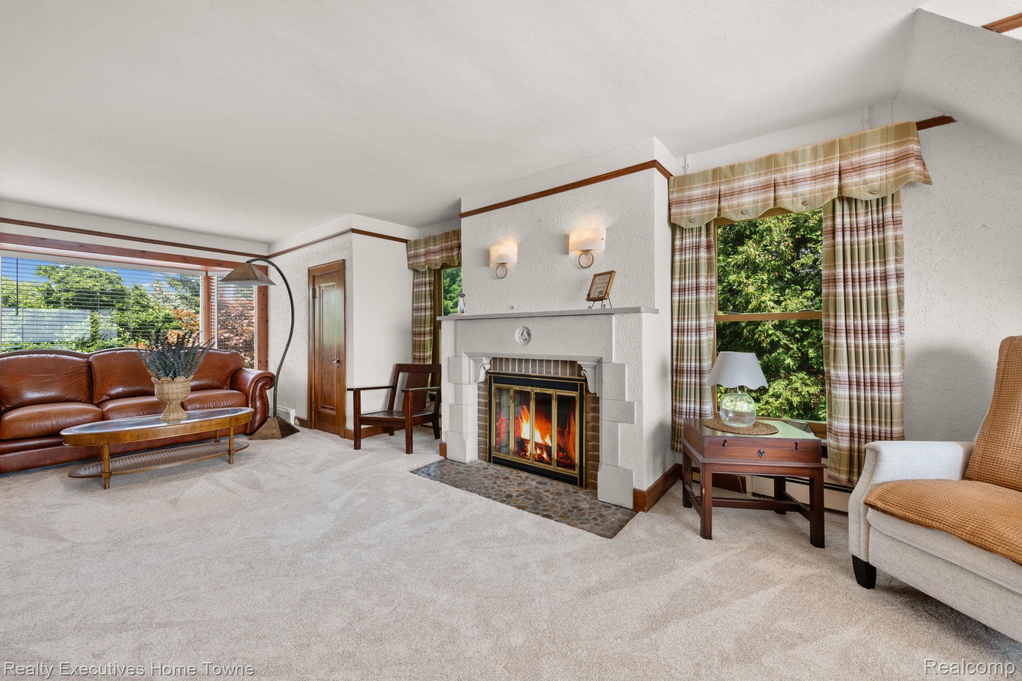 8308 Lakeshore Road Fort Gratiot, MI 48059 - Photo 68 of 79 Living area featuring a prominent fireplace with a light-colored mantel, sconce lighting, and a dark stone hearth